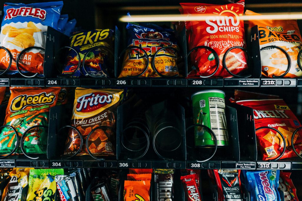 pexels photo 5495383 5495383 Close-up of a vending machine filled with popular snack brands like Cheetos and Fritos.